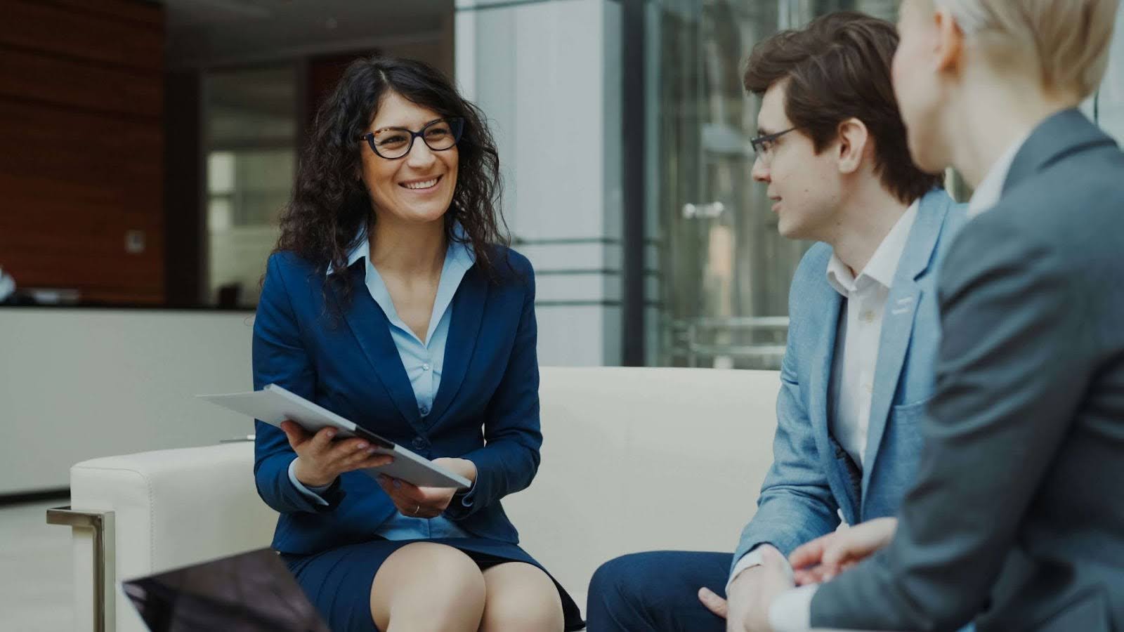Business professionals discussing recruitment goals in a modern office, representing key considerations when developing an effective tech hiring strategy.