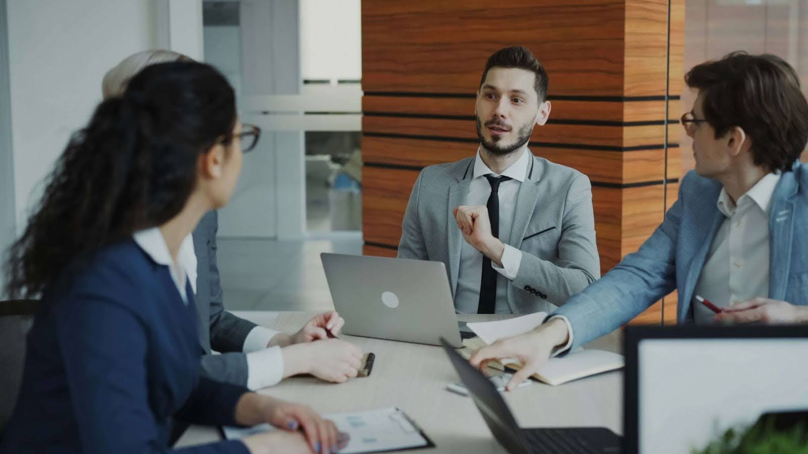 Team of professionals discussing recruitment performance and optimisation tactics in a meeting, illustrating how to improve and refine IT and tech hiring strategies.