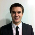 Man in a suit smiling at the camera.