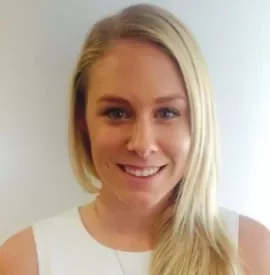 Smiling woman with long blonde hair in a white shirt.