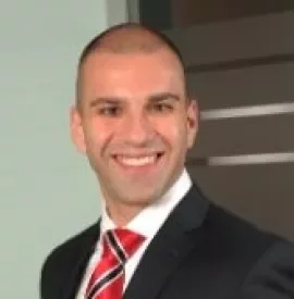 Smiling person in a suit and red striped tie