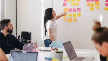 Team brainstorming session with sticky notes on the wall.