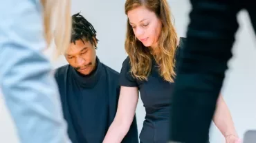 Two people collaborating at a table with focus on documents.