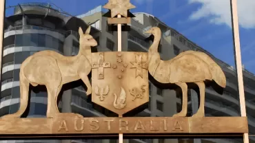 Australian coat of arms with kangaroo and emu, reflected in glass building windows.