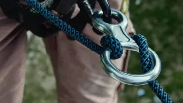 Close-up of a climbing rope tied through a metal loop.