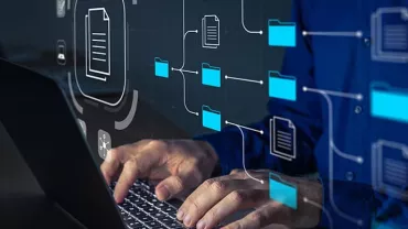 Person working on a laptop with digital file and folder icons.