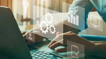 Person typing on laptop with digital icons of gears, charts, and graphs.