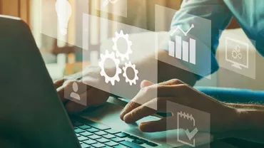 Person typing on laptop with digital icons of gears, charts, and graphs.