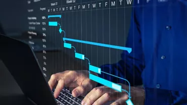 Person using a laptop with a project management chart overlay on the screen.