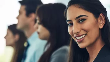 Woman smiling with confidence in a professional setting.