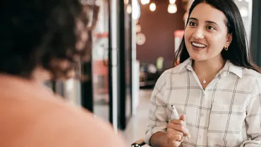 Two people having a friendly conversation in a cozy cafe.