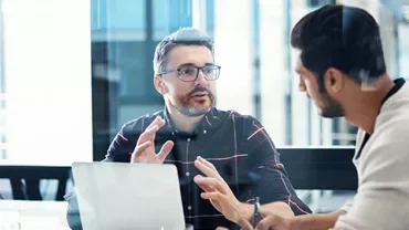 Two men discussing ideas in an office meeting.