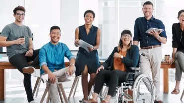 Diverse group of professionals smiling in a modern office setting.