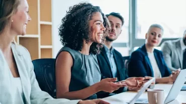 Diverse group engaged in a meeting with laptops.
