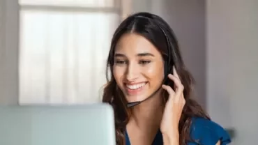 A woman with a headset speaks on the phone, representing career growth opportunities for top talent retention.