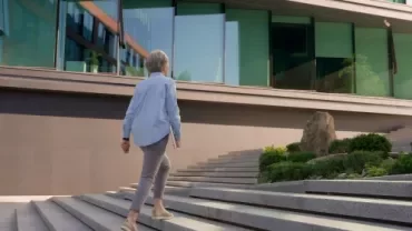 A senior female professional walking up the stairs