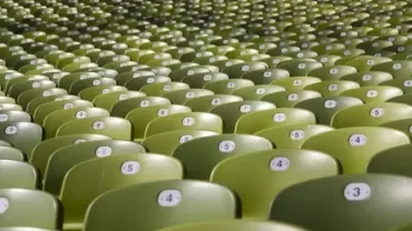 Rows of empty green stadium seats with numbered labels.