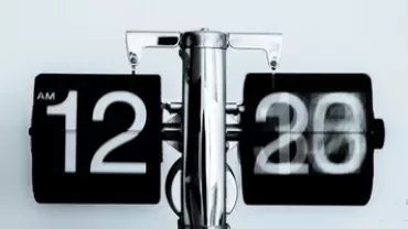 Retro flip clock showing 12:20 AM with a blurred motion effect.