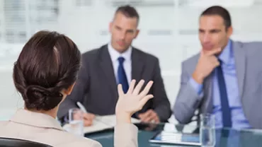 Woman in a business meeting with two men in suits.