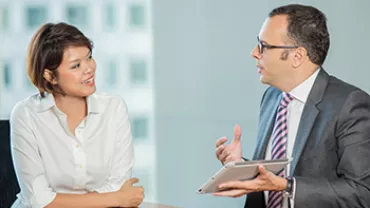 Two people sitting at a table, engaged in a conversation.