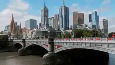 City skyline with a river and bridge in foreground.