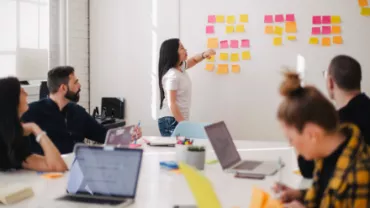 Team brainstorming with sticky notes on a whiteboard.