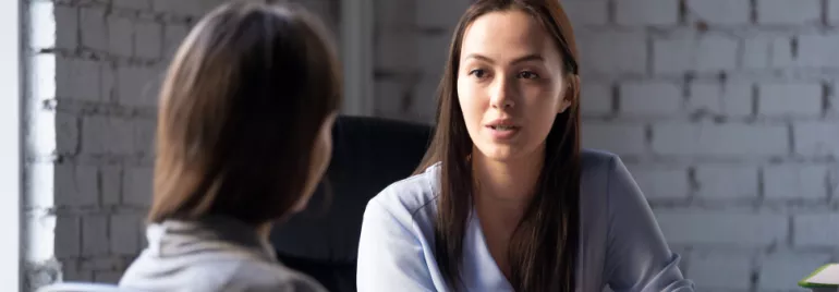 Two people engaged in a serious conversation in an office setting.