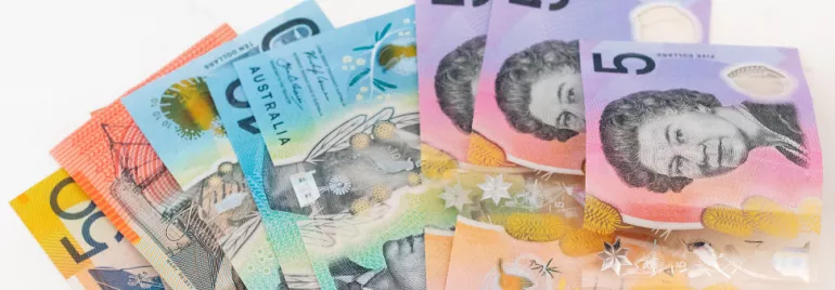 A stack of Australian dollar banknotes in various denominations.