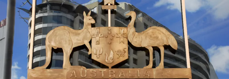 Australian coat of arms with kangaroo and emu, reflected in glass building windows.