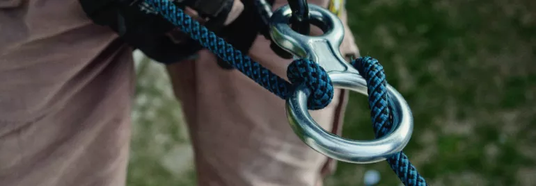Close-up of a climbing rope tied through a metal loop.