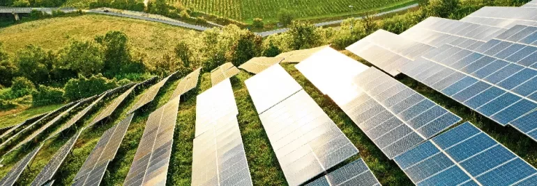 Aerial view of solar panels in a green field.