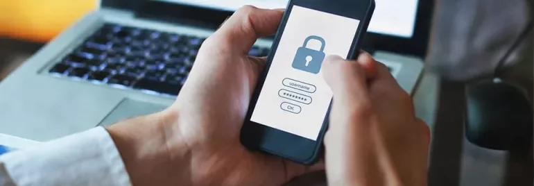 Person uses smartphone for secure login with a lock icon on the screen.
