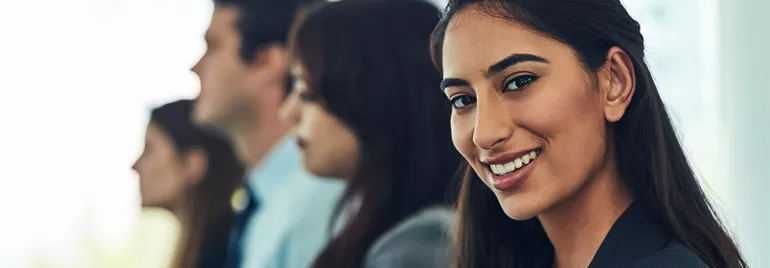 Woman smiling with confidence in a professional setting.