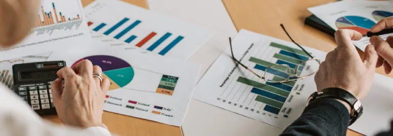 Business team reviewing charts and graphs on paper reports.