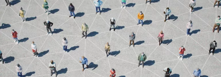 Aerial view of people standing on a geometric pattern on concrete, each casting a shadow.