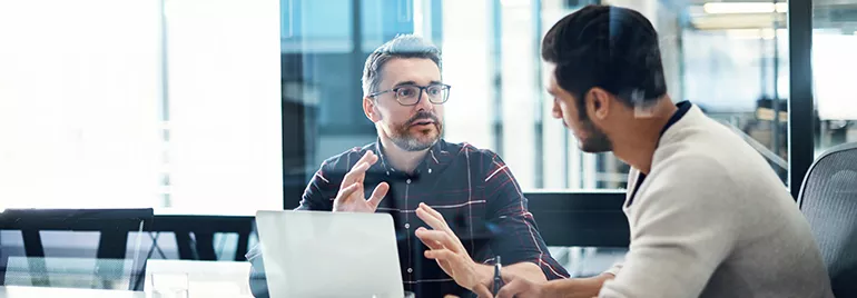 Two men discussing ideas in an office meeting.