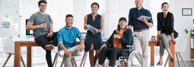 Diverse group of professionals smiling in a modern office setting.