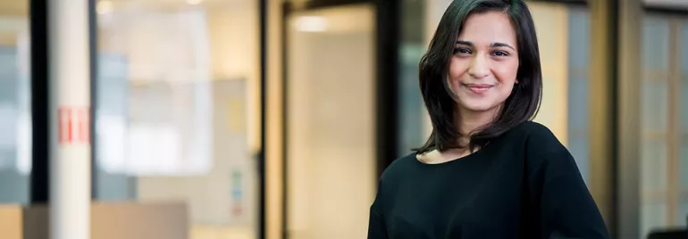 Person smiling in a modern office setting.