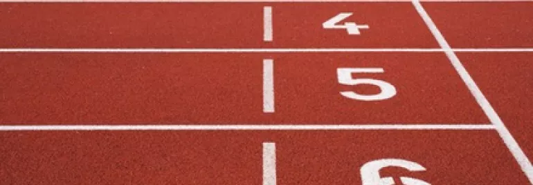 Red running track with white numbered lanes 1 to 6