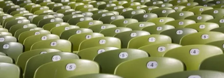 Rows of empty green stadium seats with numbered labels.