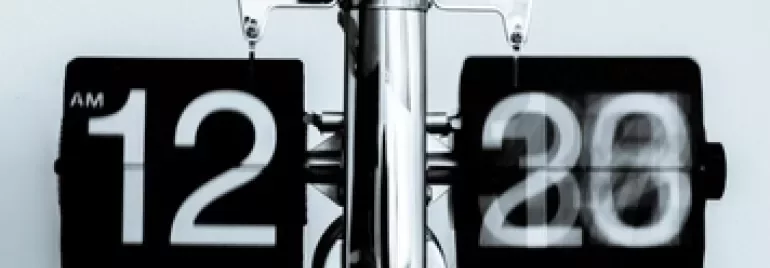 Retro flip clock showing 12:20 AM with a blurred motion effect.