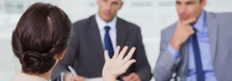 Woman in a business meeting with two men in suits.