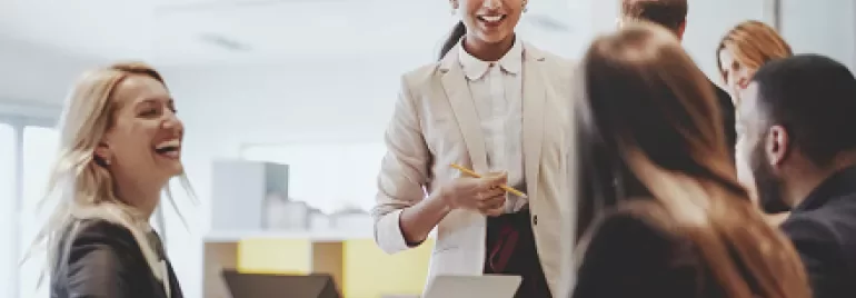 Group of professionals in a meeting, smiling and interacting.