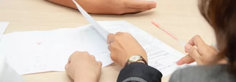 People reviewing documents at a desk.