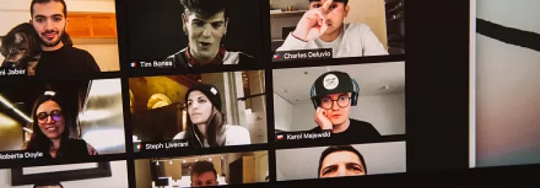 A virtual meeting with multiple participants displayed in a grid on a laptop screen.