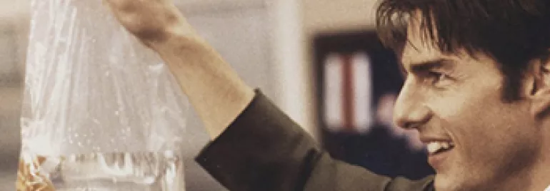 A person holding a plastic bag with a goldfish inside.
