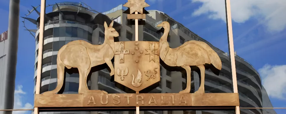 Australian coat of arms with kangaroo and emu, reflected in glass building windows.