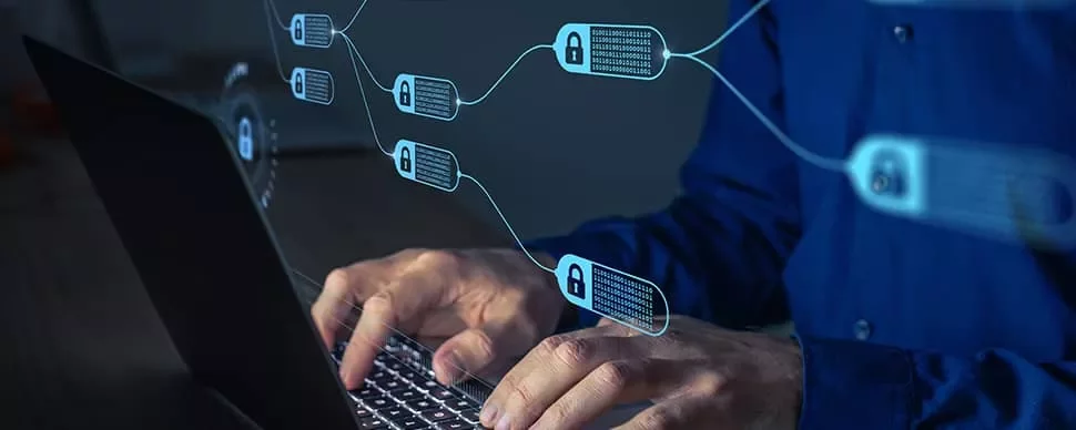 Person typing on laptop with digital blockchain network overlay.