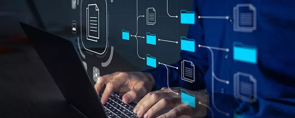 Person working on a laptop with digital file and folder icons.