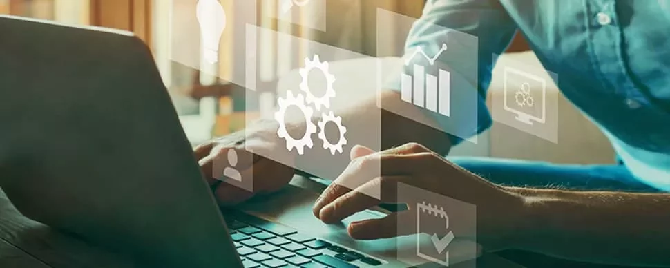 Person typing on laptop with digital icons of gears, charts, and graphs.